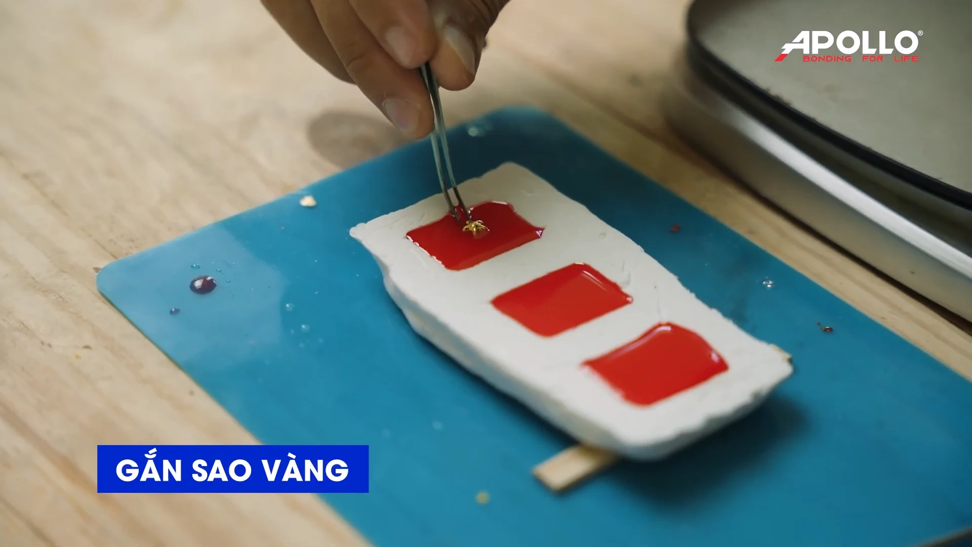 Rót phần resin đã pha vào khuôn silicone, sau đó đặt ngôi sao vàng vào chính giữa huy hiệu và điều chỉnh cho cân đối.